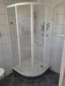 a shower in a bathroom with white tiled walls at Ferienwohnung Heinz Romes in Wimbach +16 photos