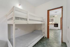 a white bunk bed in a room with a doorway at Buggerru Hugo House in Buggerru