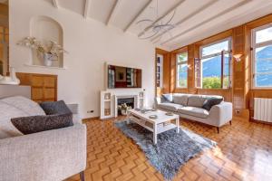 a living room with two couches and a table at Villa Il Cigno Lakeside in Oliveto Lario
