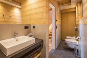 two images of a bathroom with a sink and a toilet at Chalet Henne- Hochgruberhof in Selva dei Molini +14 photos