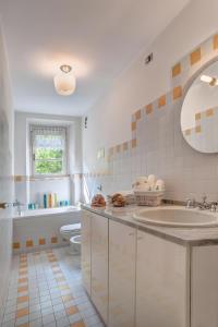 a bathroom with a sink and a toilet and a mirror at Villa Il Cigno Lakeside in Oliveto Lario +30 photos
