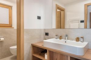 a bathroom with a white sink and a toilet at Les Ciases Chalets Dolomites Apt 6 in San Vigilio Di Marebbe +36 photos