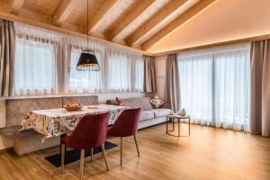 a living room with a table and a couch at Les Ciases Chalets Dolomites Apt 6 in San Vigilio Di Marebbe