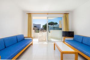 a living room with blue couches and a balcony at Apartament Massanet ba in Canyamel