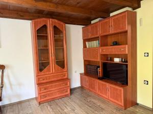 a large wooden cabinet with a microwave in a room at Hideaway Kos in Loka pri Žusmu