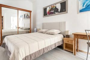 a white bedroom with two beds and a table at Duplex Appartement 300m de la mer in Fréjus