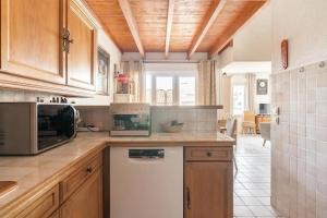 a kitchen with wooden cabinets and a white dishwasher at Duplex Appartement 300m de la mer in Fréjus +11 photos