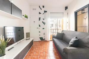 a living room with a couch and a flat screen tv at Apartamento La Listada Alto in La Listada