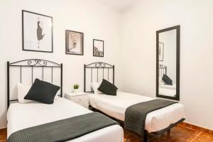 two beds in a room with two mirrors at Apartamento La Listada Alto in La Listada