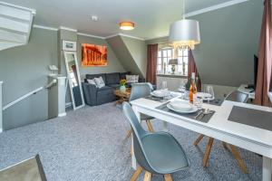 a dining room and living room with a table and chairs at Gemütliche Wohnung Reet-Pool-Sauna in Keitum