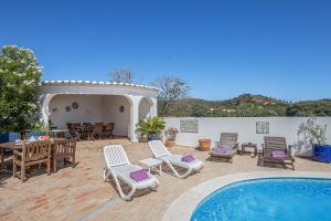 a patio with a pool and chairs and a table at Villa Sagres in Portimão