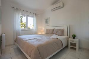 a white bedroom with a large bed and a window at Villa Sagres in Portimão +25 photos
