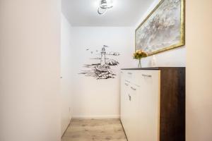 a room with a cabinet and a painting on the wall at Hochwertige Ferienwohnung in Lübeck +12 photos