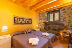 a bedroom with a bed and a stone wall at Casa Guillem 2 in Tavascan