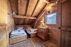 a bedroom with two beds in a wooden cabin at Chalet 6p Classique - L'ourson in Verchaix