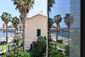 a view from a window of a beach and palm trees at Loft il Mare Rio Marina front sea in Rio Marina