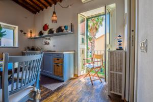 a kitchen with blue cabinets and a table and chairs at Loft il Mare Rio Marina front sea in Rio Marina