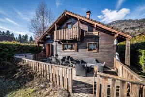 a log cabin with a deck and chairs at Chalet 6p Classique - L'ourson in Verchaix