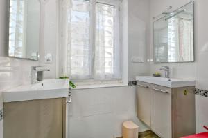 a white bathroom with a sink and a mirror at La Maison de Port Lin in Le Croisic +30 photos