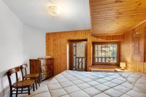 a bedroom with a bed and a desk and a window at Maison Tillier Valtournenche in Valtournenche