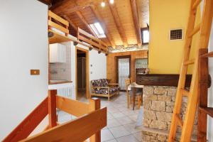 a kitchen and living room with wooden ceilings and a staircase at Maison Tillier Valtournenche in Valtournenche
