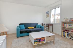 a living room with a blue couch and a table at La Maison de Port Lin in Le Croisic