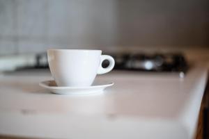 a white coffee cup sitting on a counter at La Capannuccia B in Ansedónia +4 photos