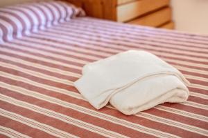 a white towel laying on top of a bed at La Capannuccia B in Ansedónia
