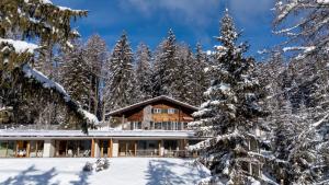 a log home in the woods with snow covered trees at Chalet Magdalena und Lodges in Avelengo