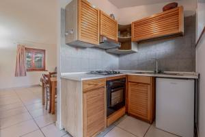 a kitchen with wooden cabinets and a stove top oven at La Capannuccia B in Ansedónia