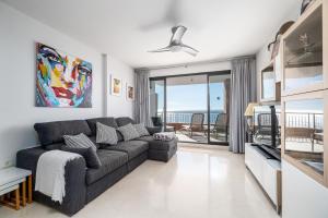 a living room with a couch and a view of the ocean at Roya Vistamar in Torrox Costa