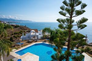 a villa with a swimming pool and a tree at Roya Vistamar in Torrox Costa