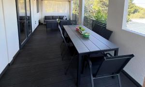 a porch with a wooden table and chairs on a balcony at Mobile Home Ella in Murter +8 photos