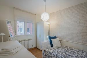 a bedroom with a bed and a white brick wall at Rodrigo in Palencia