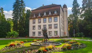 a building with a statue in front of a garden at Haus Sonnenschein Bad Säckingen in Bad Säckingen