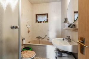 a bathroom with a tub and a sink and a toilet at Haus Sonnenschein Bad Säckingen in Bad Säckingen +30 photos