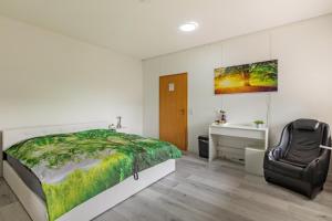 a bedroom with a bed and a chair at Haus Sonnenschein Bad Säckingen in Bad Säckingen