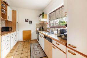 a kitchen with white cabinets and a window at Haus Sonnenschein Bad Säckingen in Bad Säckingen