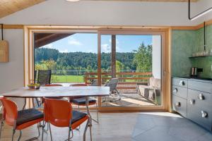 ein Esszimmer mit Tisch und Stühlen und einem Balkon in der Unterkunft Kesselmoos in Deutschnofen