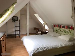 a bedroom with a white bed and a staircase at Gîte Le Clos aux Cerises in Eu