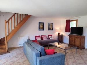 a living room with a couch and a tv at Gîte Le Clos aux Cerises in Eu