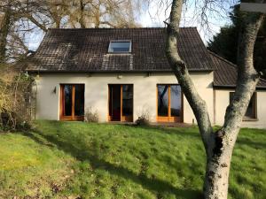 a white house with a tree in front of it at Gîte Le Clos aux Cerises in Eu