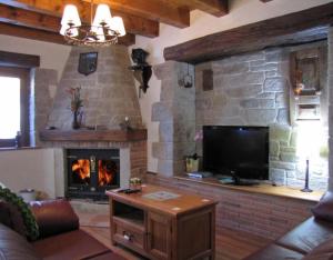 a living room with a fireplace and a flat screen tv at Casa Rural Enarakabi in Zunzarren
