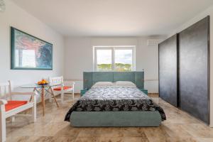 a bedroom with a bed and a table and a window at I 4 Venti in Melendugno