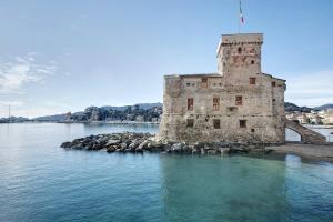 an old building in the middle of the water at Casa Nio in Rapallo