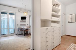 a kitchen and dining room with white cabinets and a table at Casa Nio in Rapallo