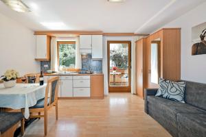 a kitchen and living room with a table and a couch at Alpenchalet Niederkofler Isabella in San Giovanni in Val Aurina