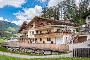a house in the mountains with a fence at Alpenchalet Niederkofler Isabella in San Giovanni in Val Aurina