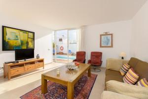 a living room with a couch and a tv at Luis iii in Puerto del Carmen
