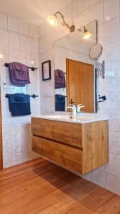 a bathroom with a sink and a mirror at Haus am Twistesee in Wetterburg +31 photos